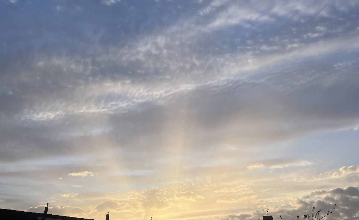 Opkomende zon met lichtstralen als symbool voor innerlijke rust en bewustzijn